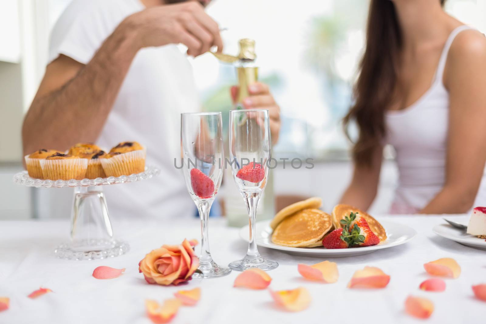 Young couple having a romantic breakfast at home in the kitchen