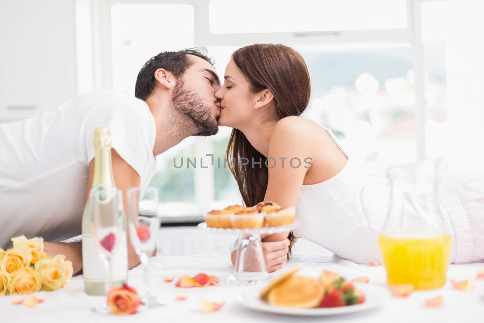 Young couple having a romantic breakfast at home in the kitchen