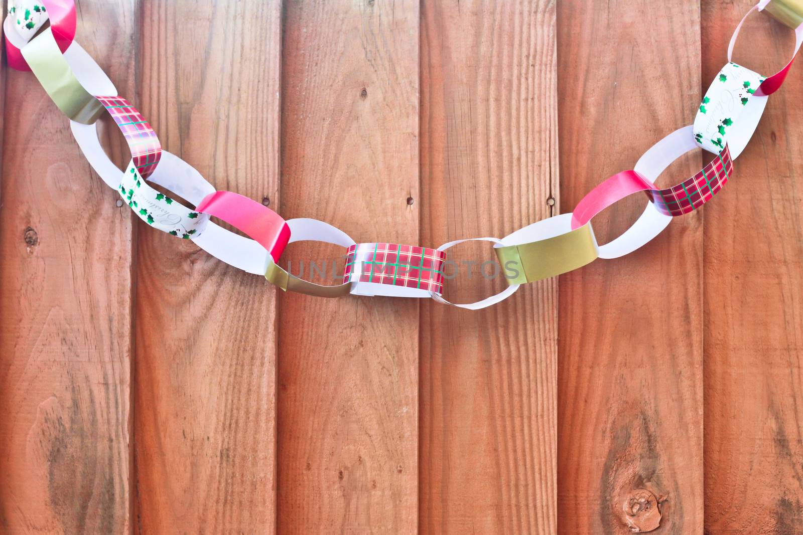 A decorative chain made from paper, on a fence