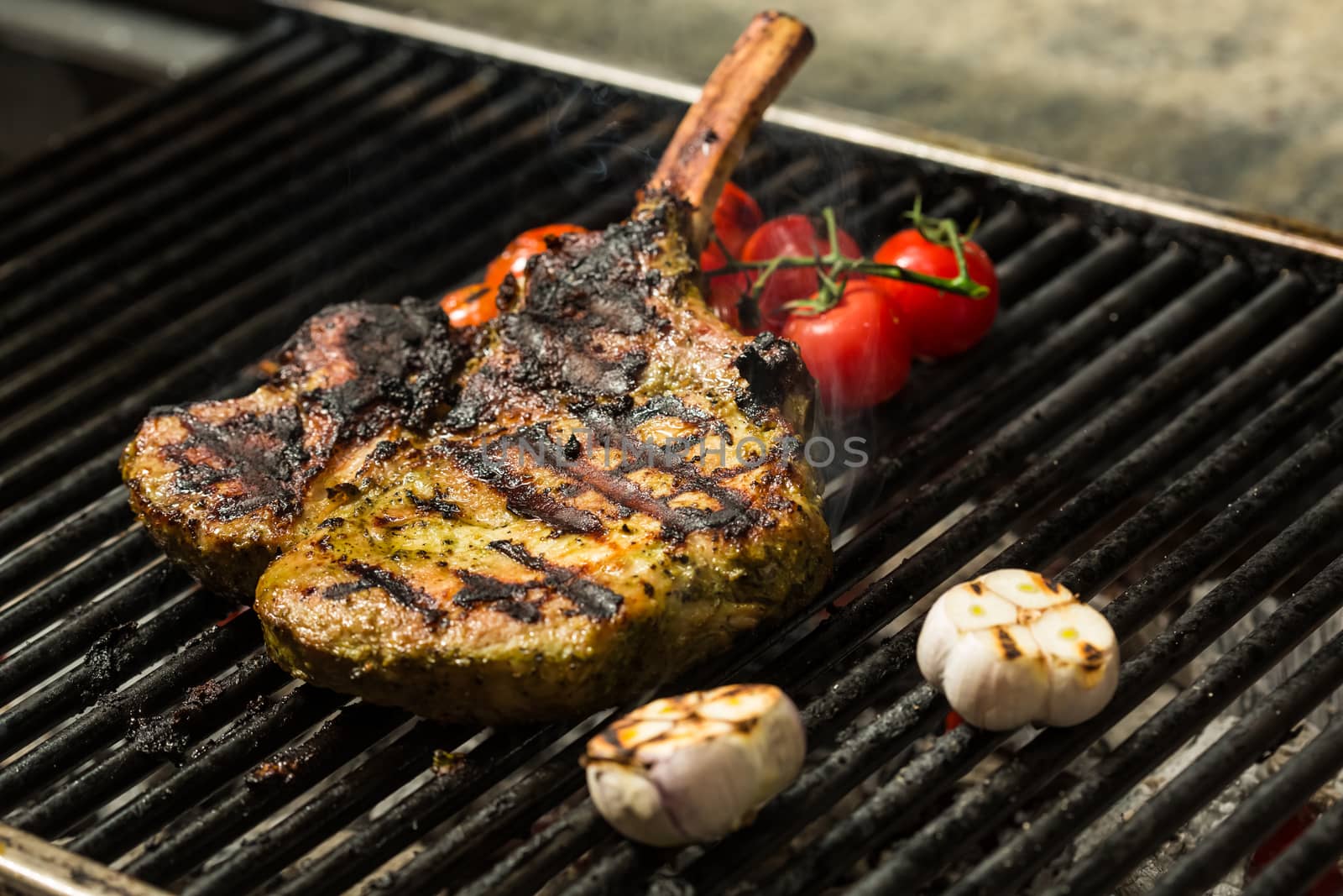 steak flame broiled on a barbecue with vegetables. shallow depth of field. 