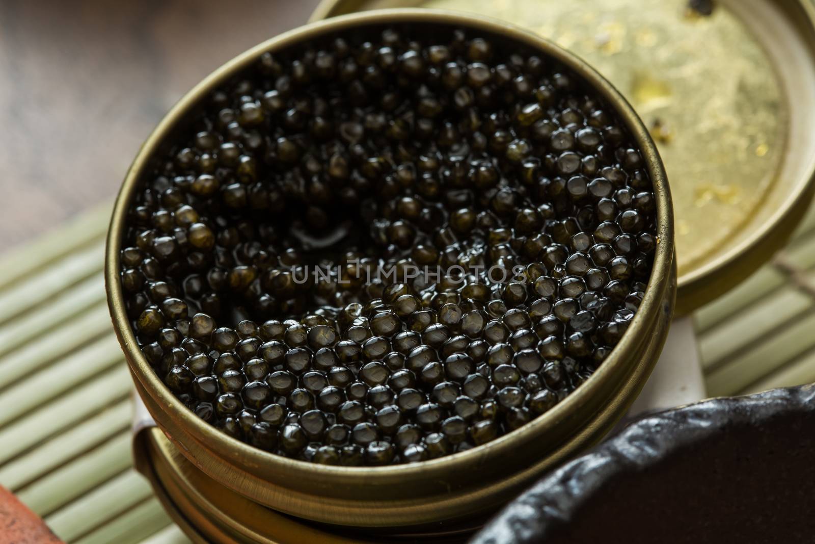 Black caviar in small round metal tin on ice