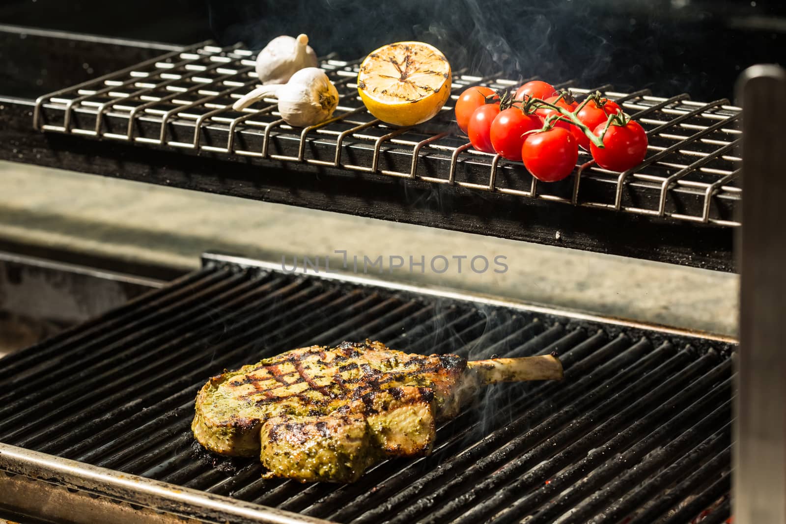 steak flame broiled on a barbecue with vegetables. shallow depth of field. 