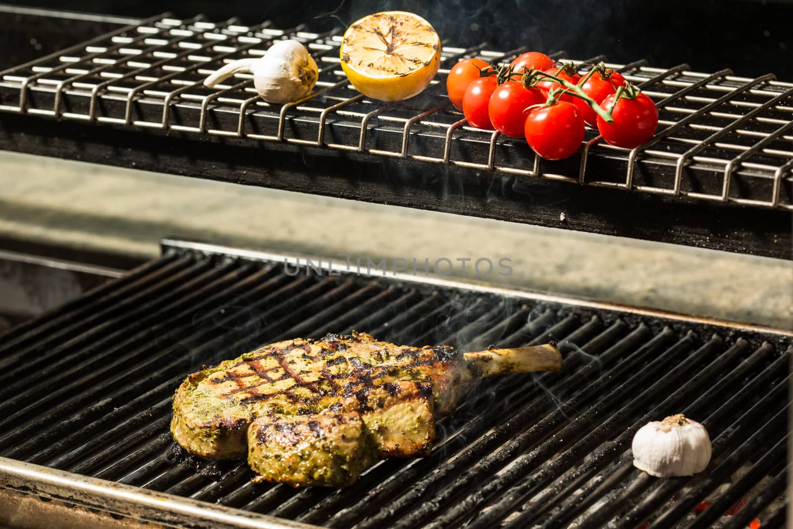 steak flame broiled on a barbecue with vegetables. shallow depth of field. 