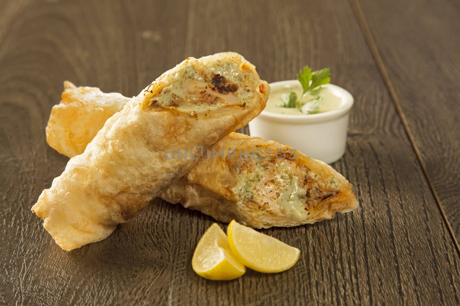 Traditional kebab paratha roll tikka wrap served on a plate with chutney, on a wooden background