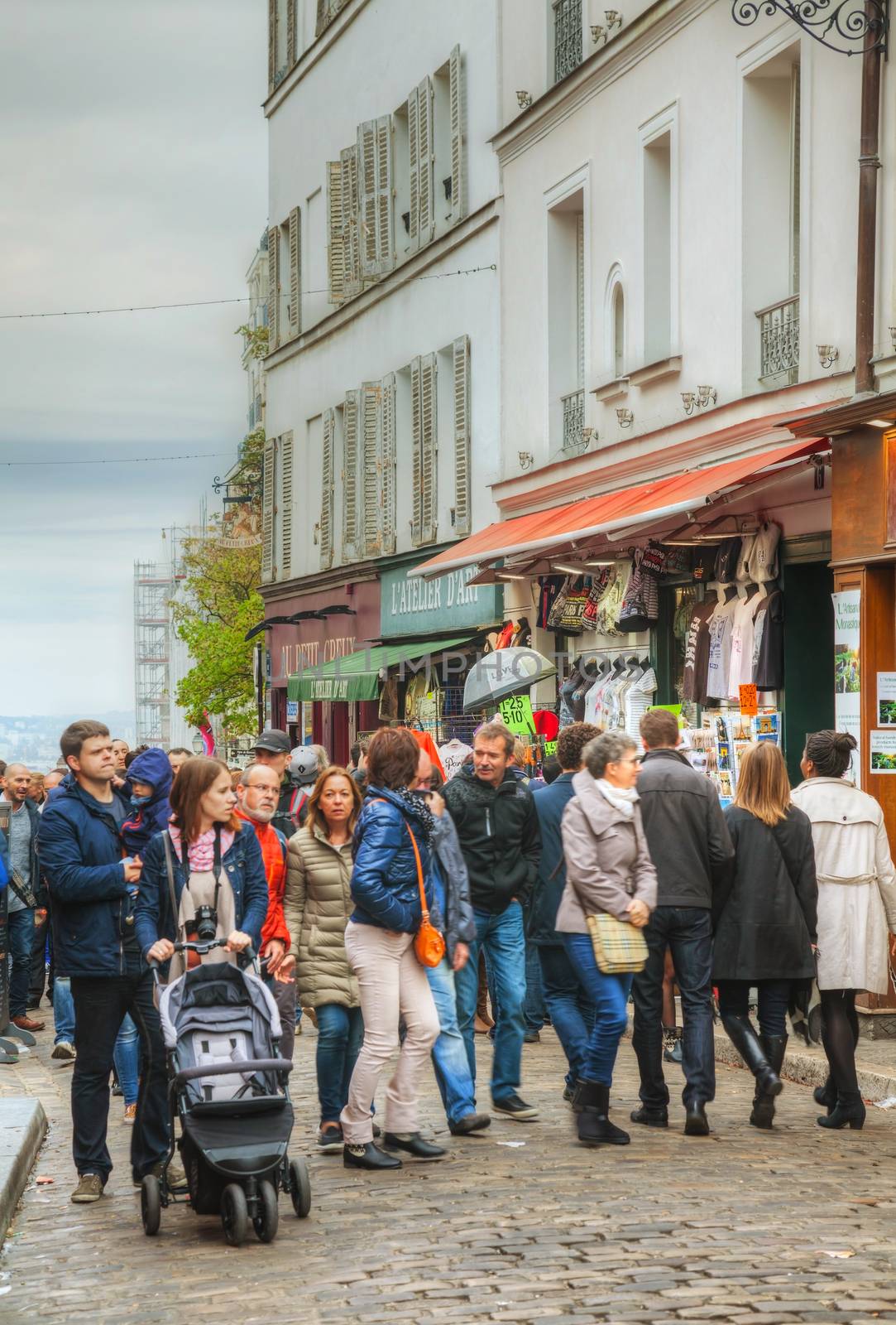 PARIS - OCTOBER 12: Crowded street on the Montmartre hill on October 12, 2014 in Paris, France. Many artists had studios or worked in or around Montmartre, including Dali, Modigliani, Monet and others.