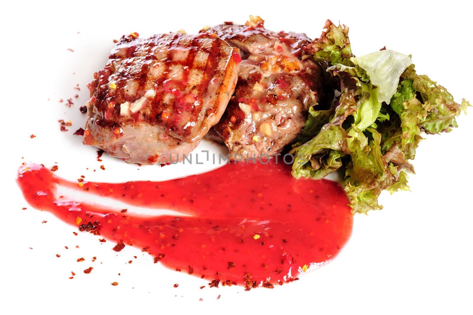 Grilled pork steaks with raspberry sauce and leaf of lettuce