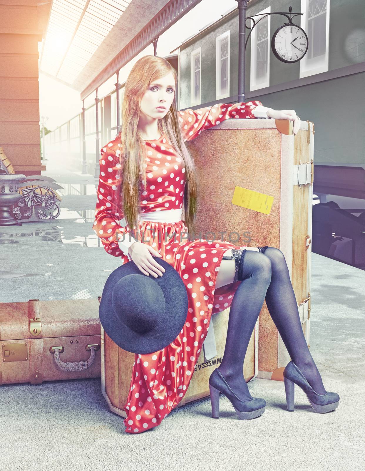 The girl sitting on the suitcase waiting at the retro railway station 