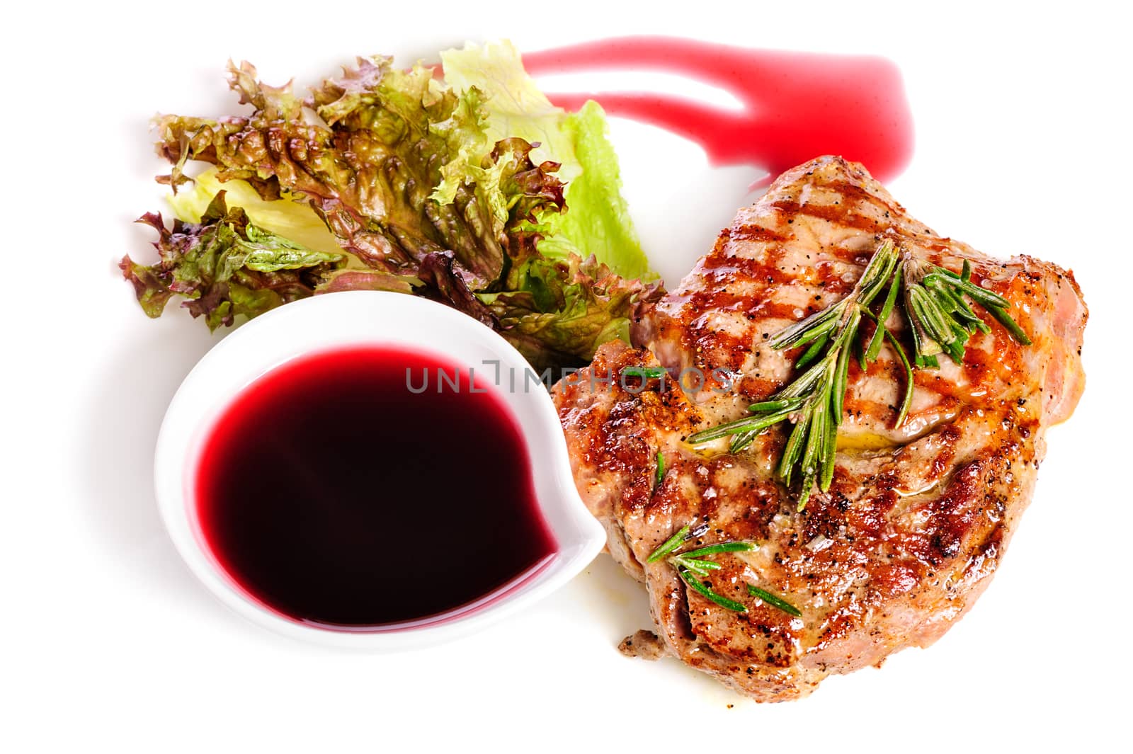 Grilled pork steaks with raspberry sauce, rosemary and leaf of lettuce