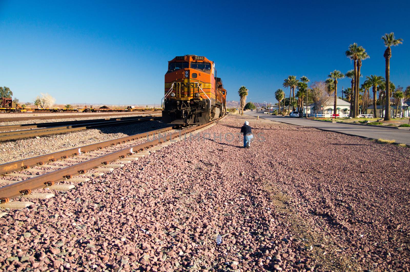 Photographer captures image of distinctive orange and yellow Burlington Northern Santa Fe Locomotive freight train No. 5240 on the tracks at the town of Needles, California. Photo taken in February 2013.