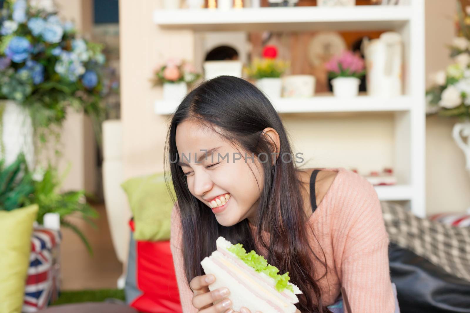 Close up pretty Asian woman eating Sandwich.