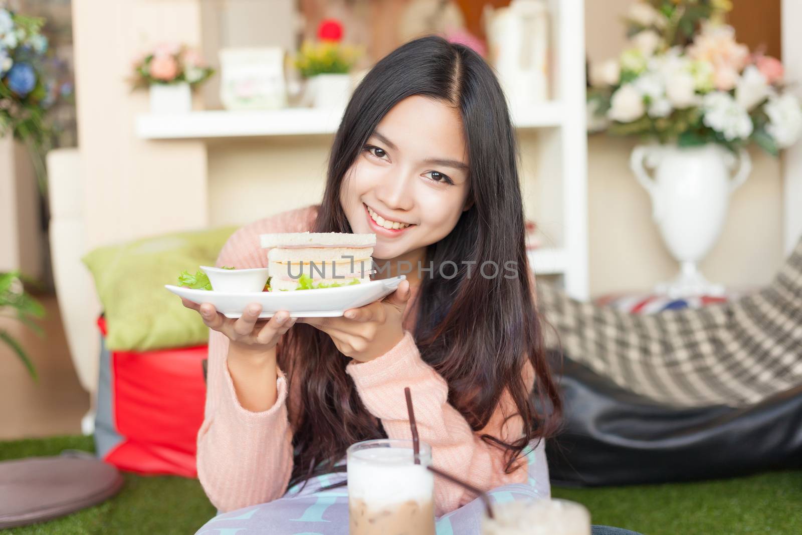 Close up pretty Asian woman eating Sandwich .