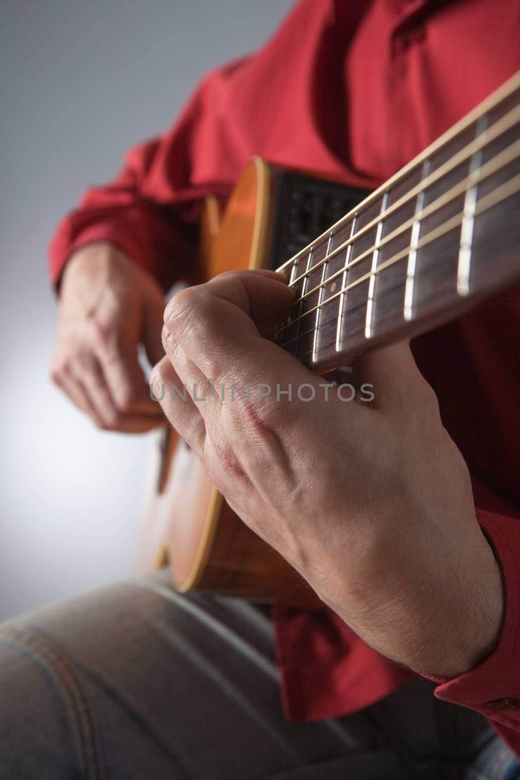 closeup of hands of a musician playing acoustic guitar