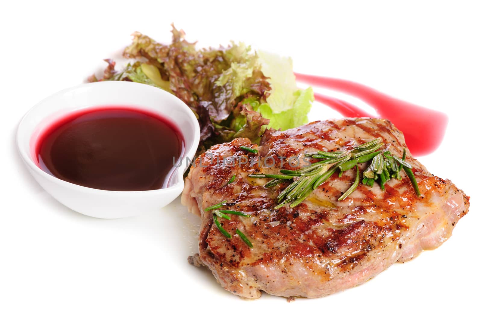 Grilled pork steaks with raspberry sauce, rosemary and leaf of lettuce