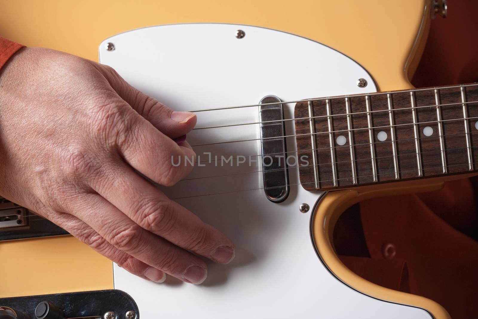 closeup of hands of a musician playing electric guitar
