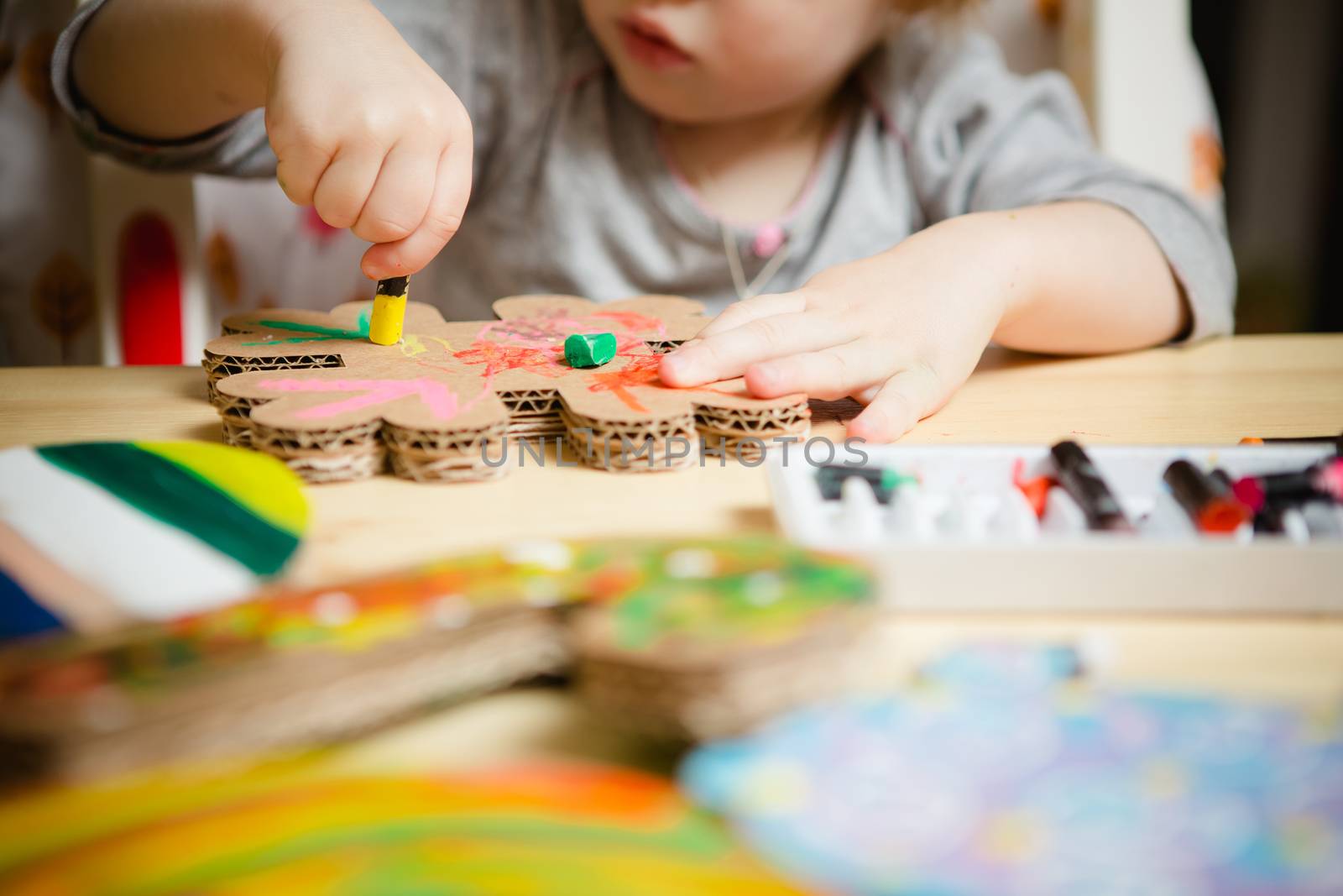 Little female baby painting with colorful paints by sarymsakov