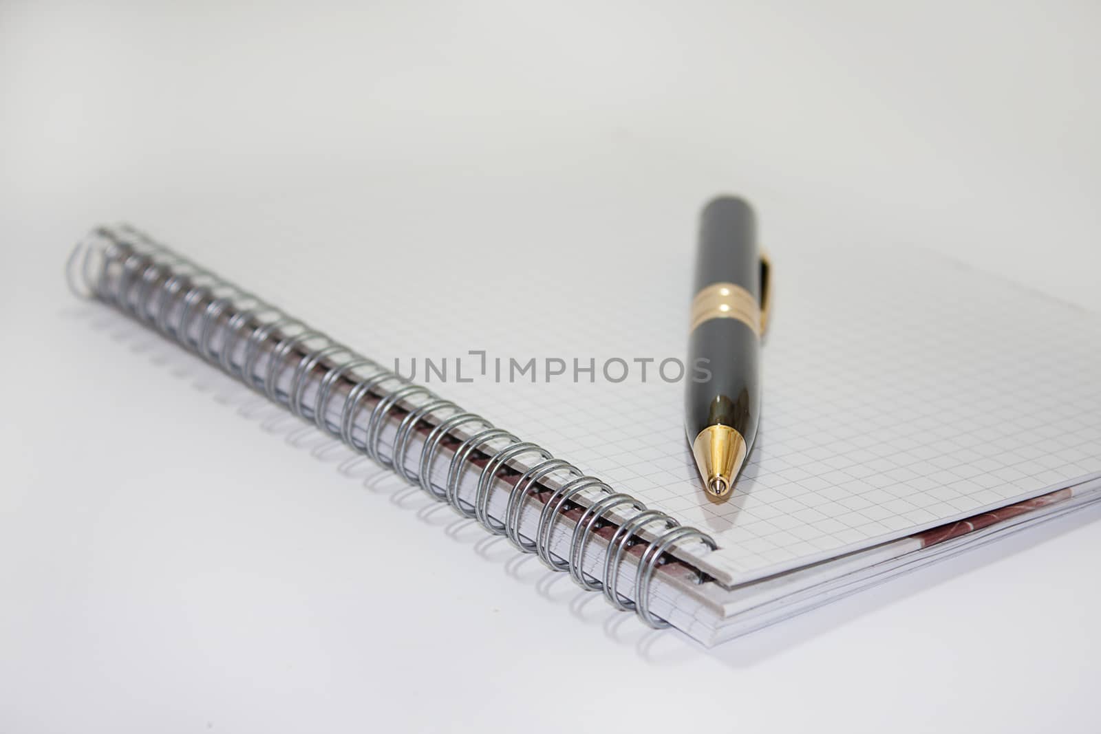 Black pen on the white paper notebook on the white background.