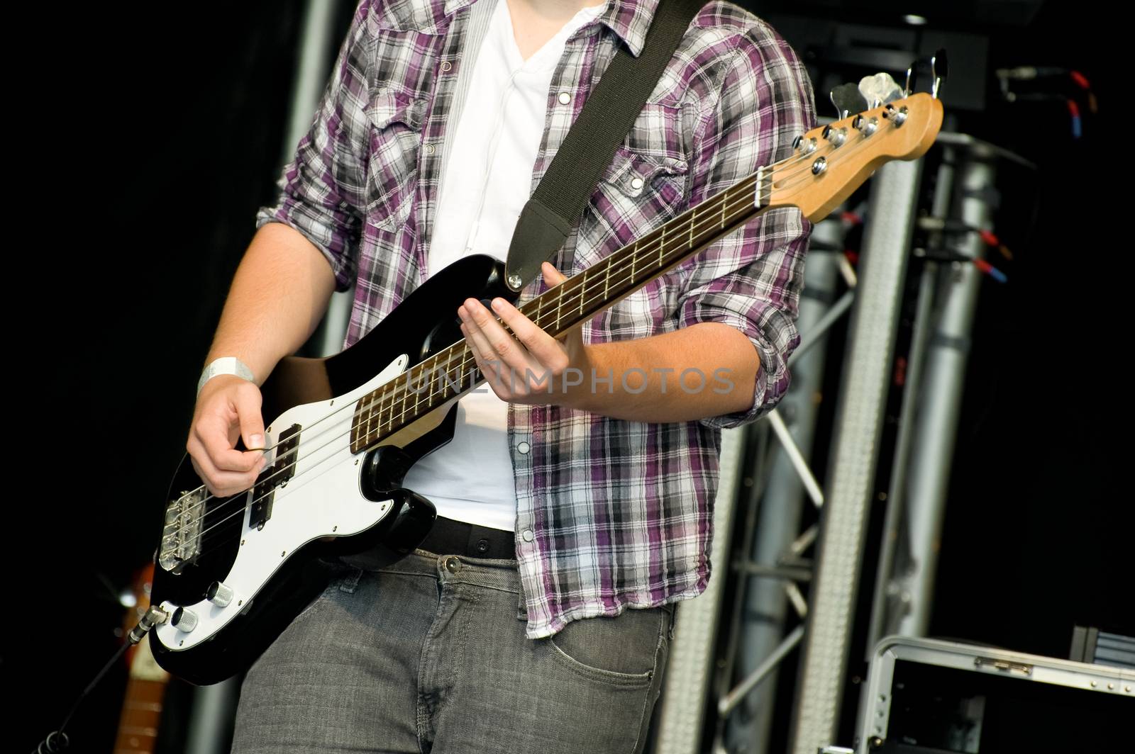 musician playing bass guitar on stage