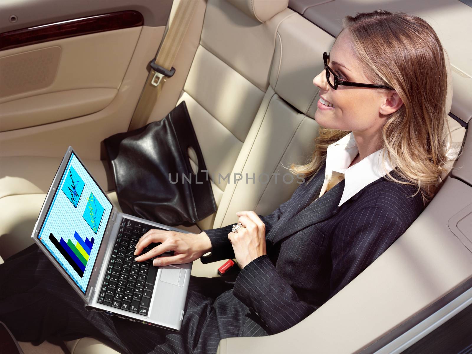 businesswoman has a fan with laptop in black car 