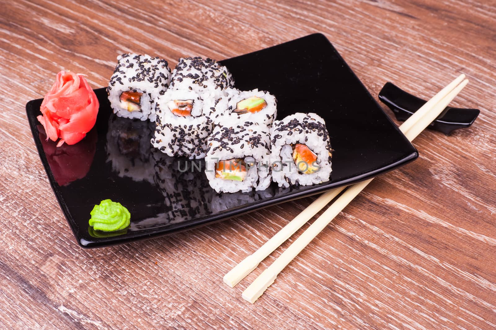 salmon and avocado sushi roll on wooden background