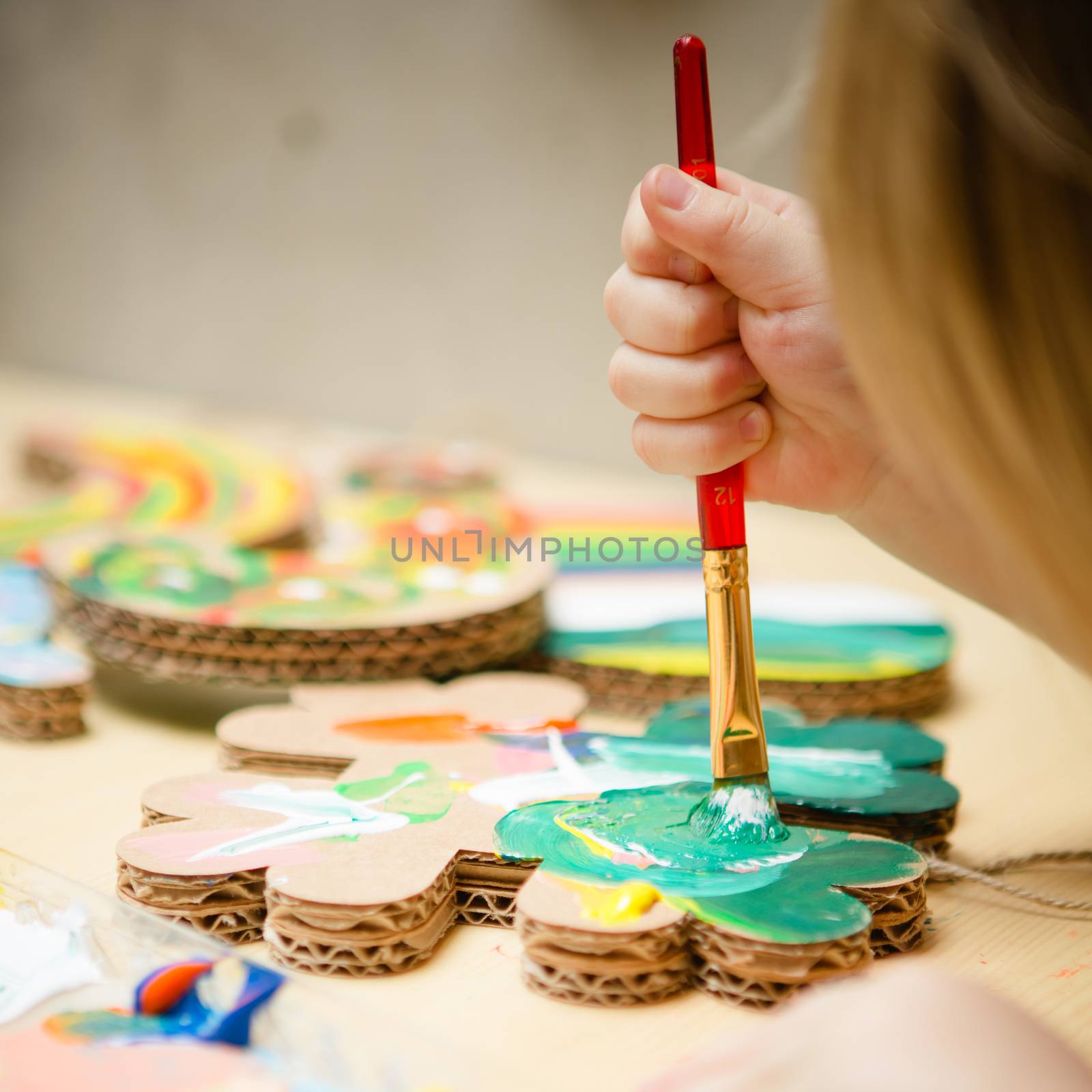 Little female baby painting with colorful paints. selective focus