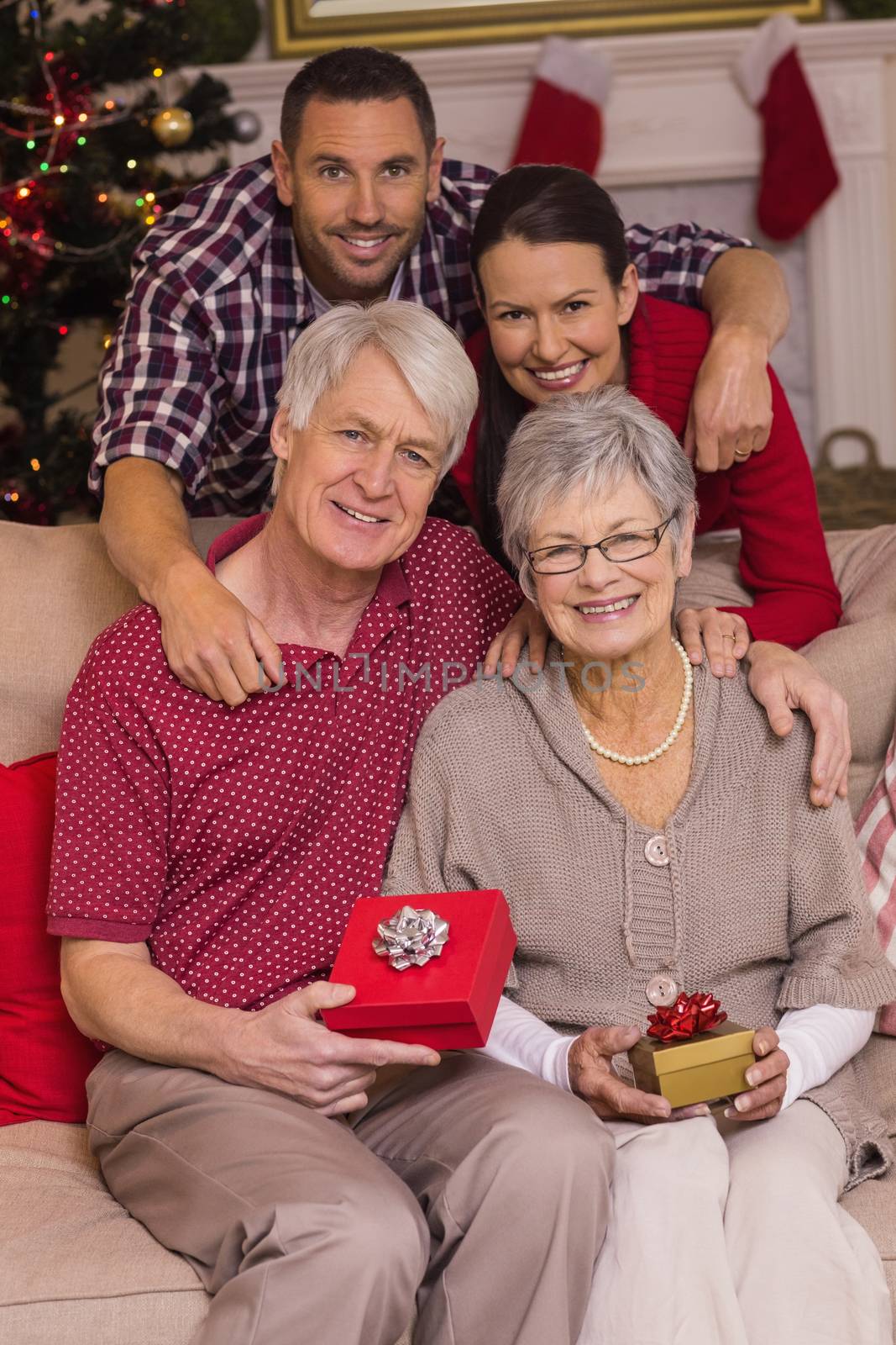 Happy family posing with presents at home in the living room