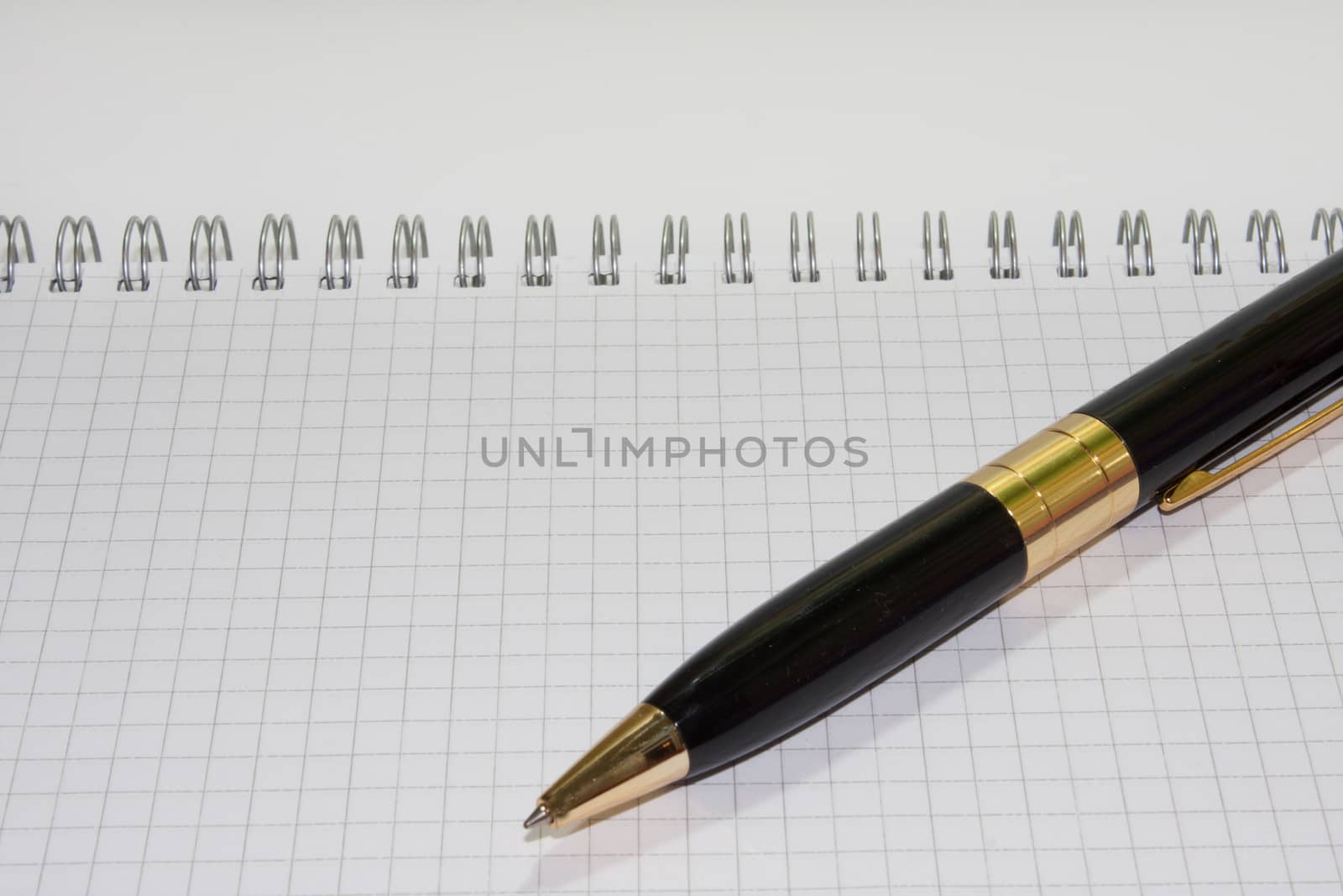 Black pen on the white paper notebook on the white background.
