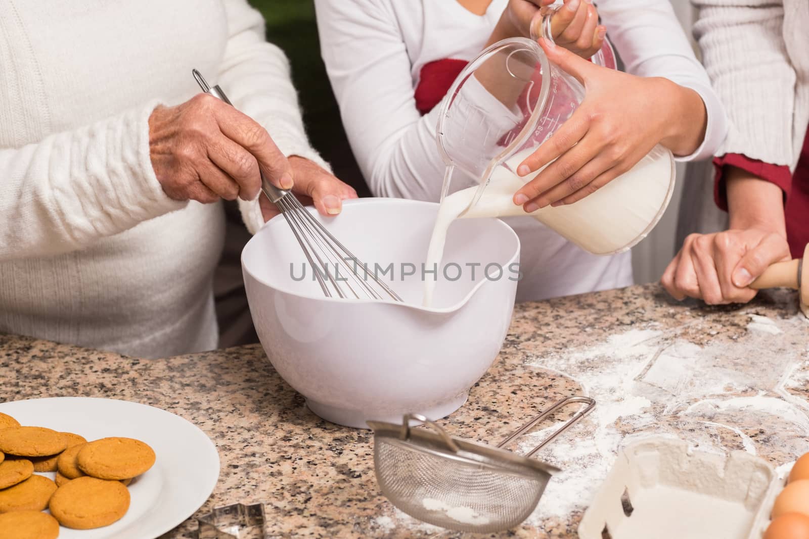 Multi-generation family baking together at home in the kitchen