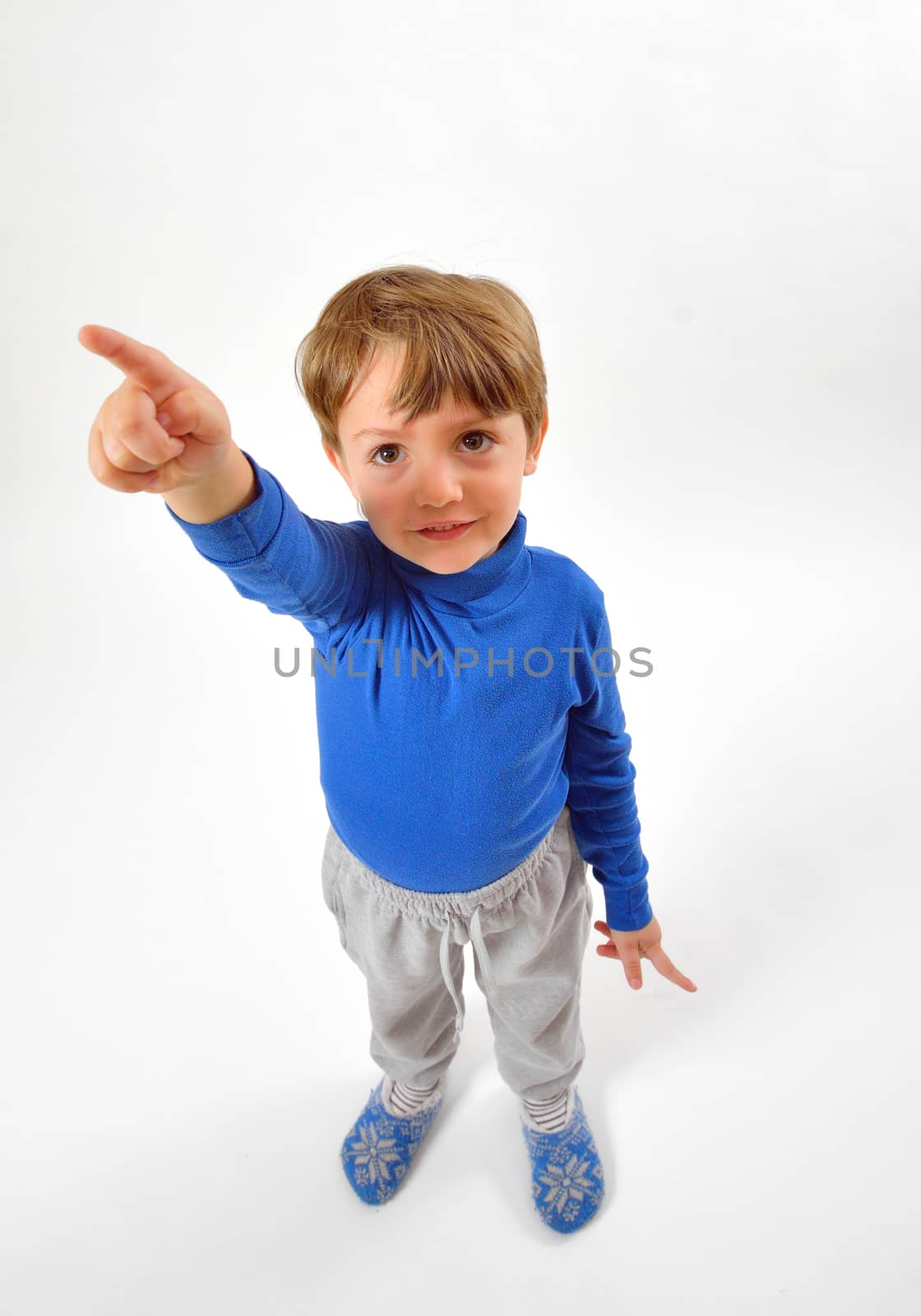 Cheerful little boy pointing up isolated