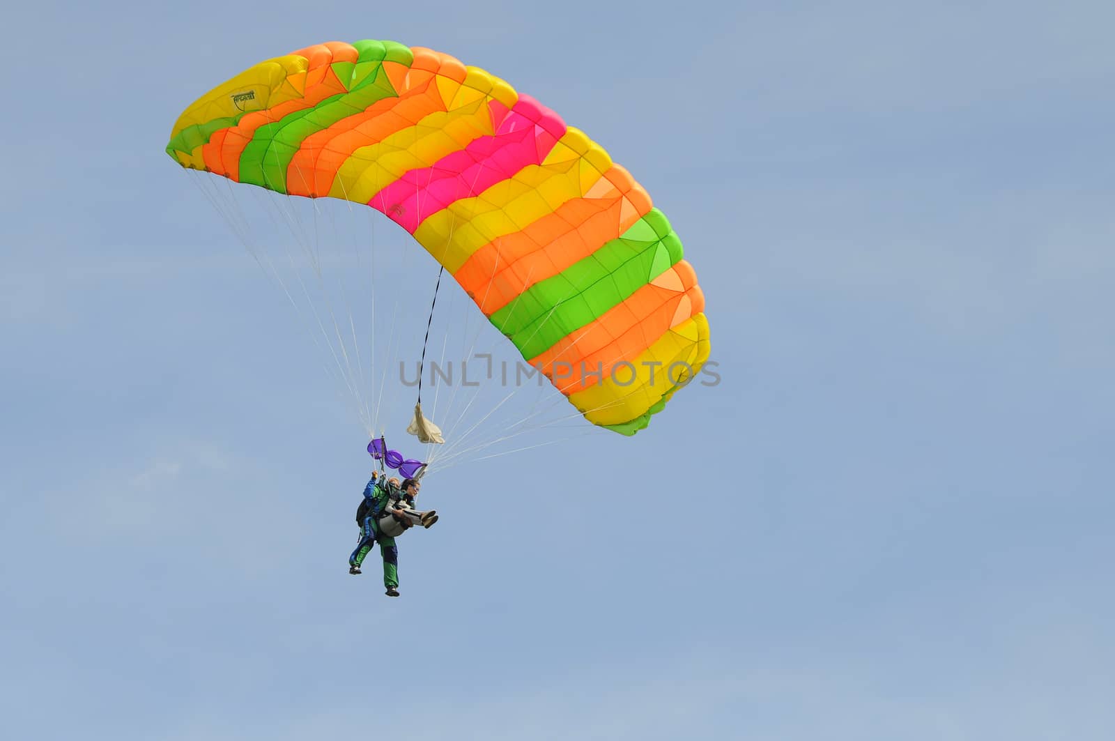 the parachutist goes down on a multi-colored parachute. by veronka72