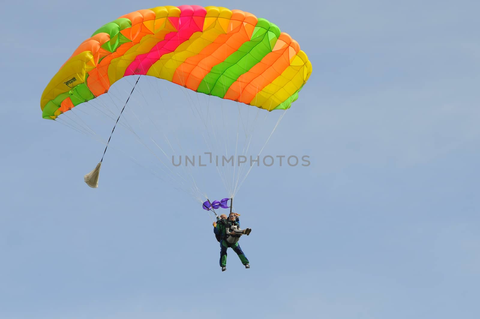 the parachutist goes down on a multi-colored parachute. by veronka72