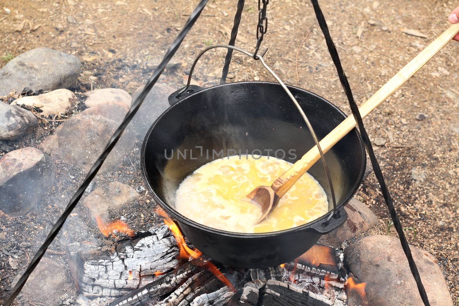 black cauldron on camping fire by taviphoto