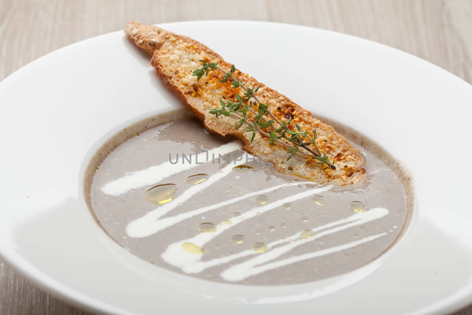 Vegetarian mushroom cream soup puree in white plate  with baked bread cheese slice