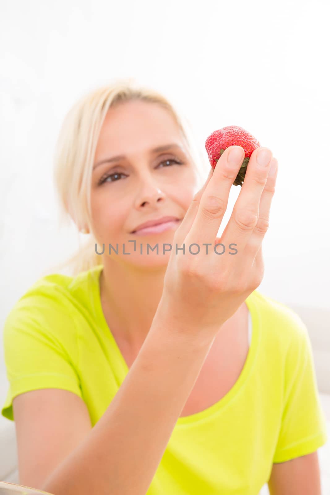 Mature woman eating strawberry			 by Spectral