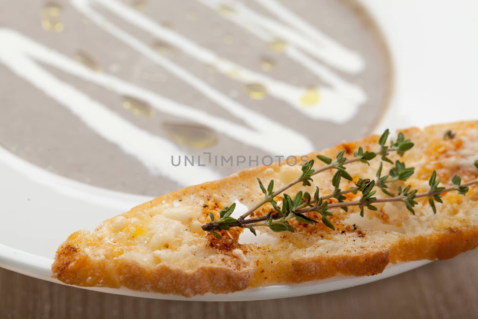 Vegetarian mushroom cream soup puree in white plate  with baked bread cheese slice