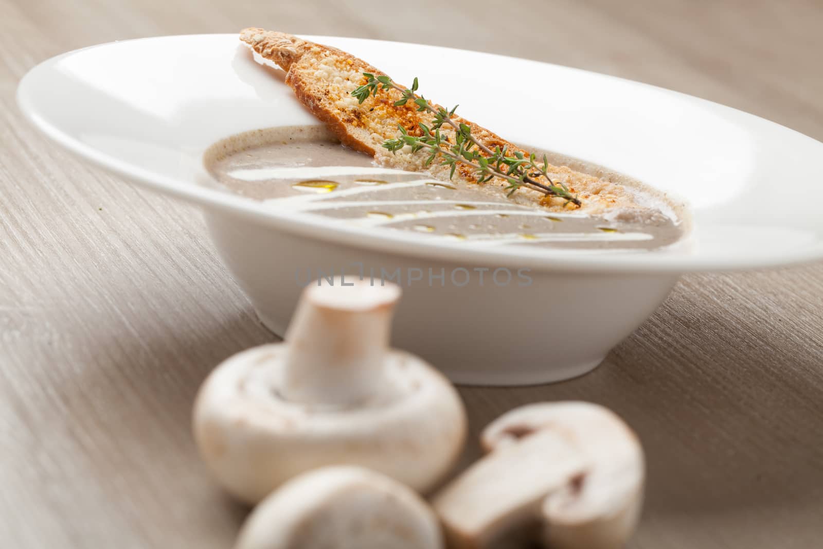 Vegetarian mushroom cream soup puree in white plate  with baked bread cheese slice