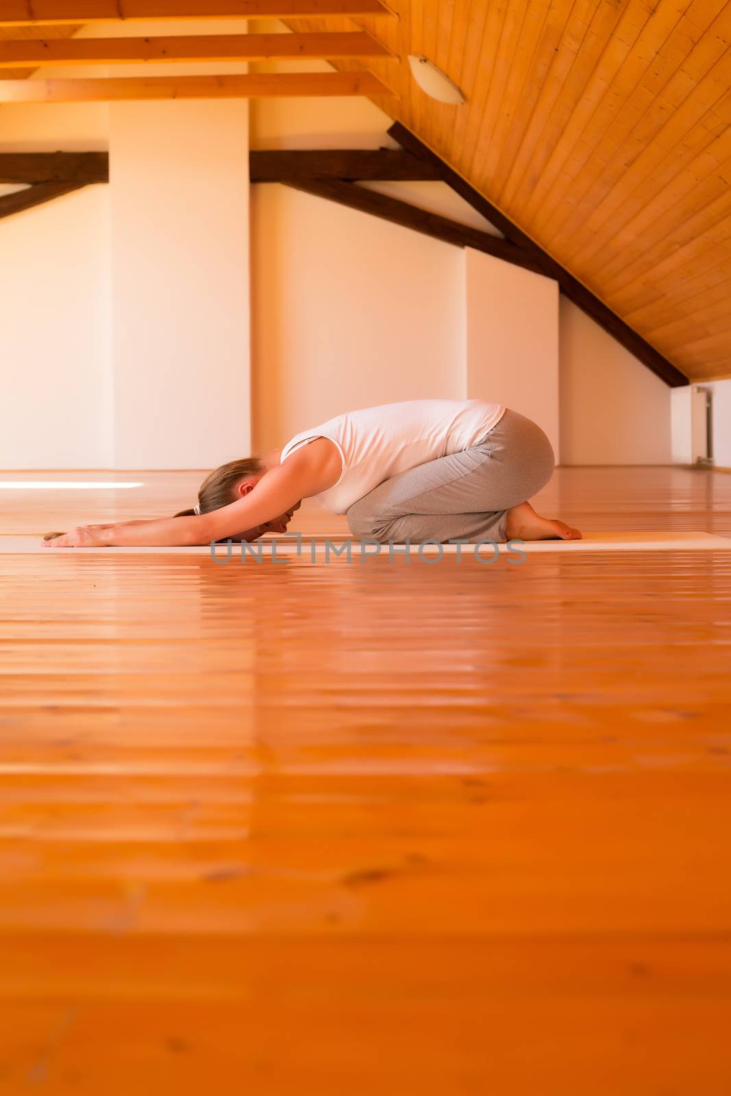 Woman practicing Yoga in a Studio by Spectral