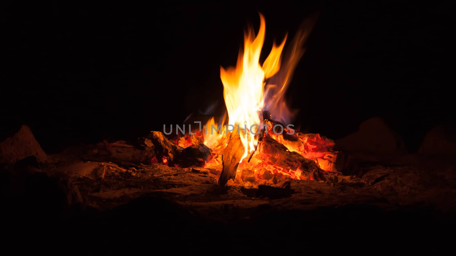 Evening camp fire burning red hot.