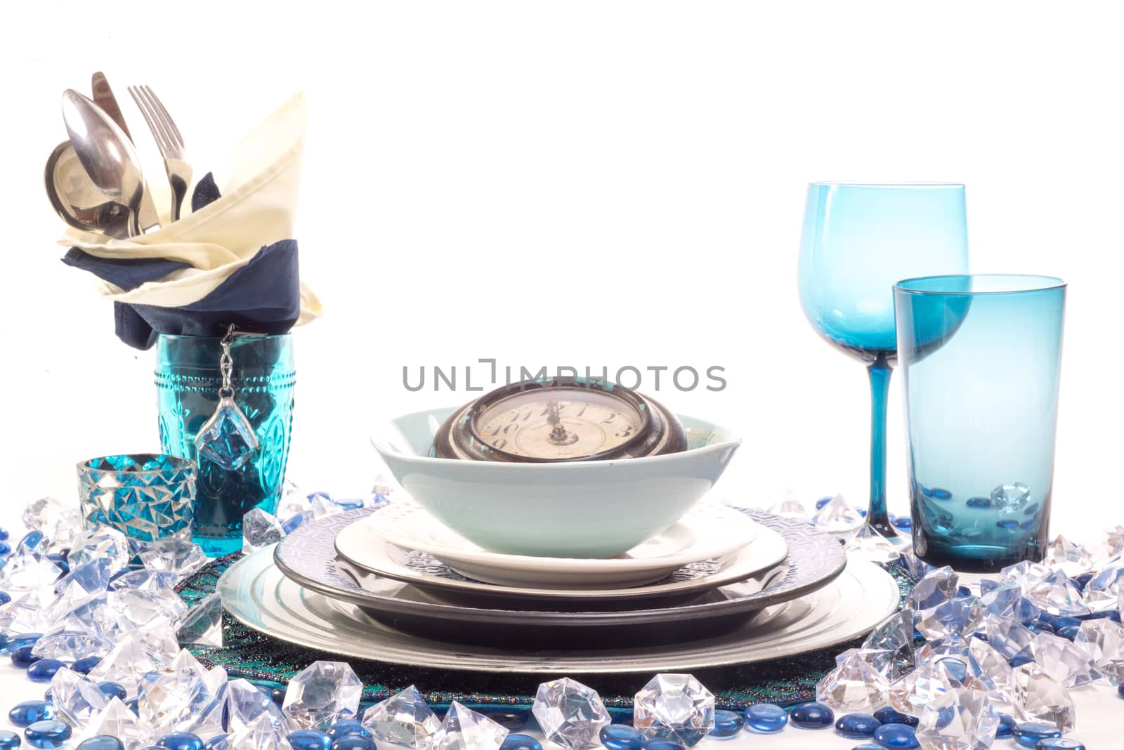 A Table setting for new year's eve party in the theme of time, complete with a clock on top of all the plates.