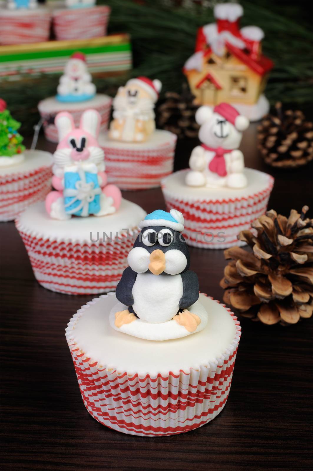 Sugar Christmas penguin figurine on glazed muffin