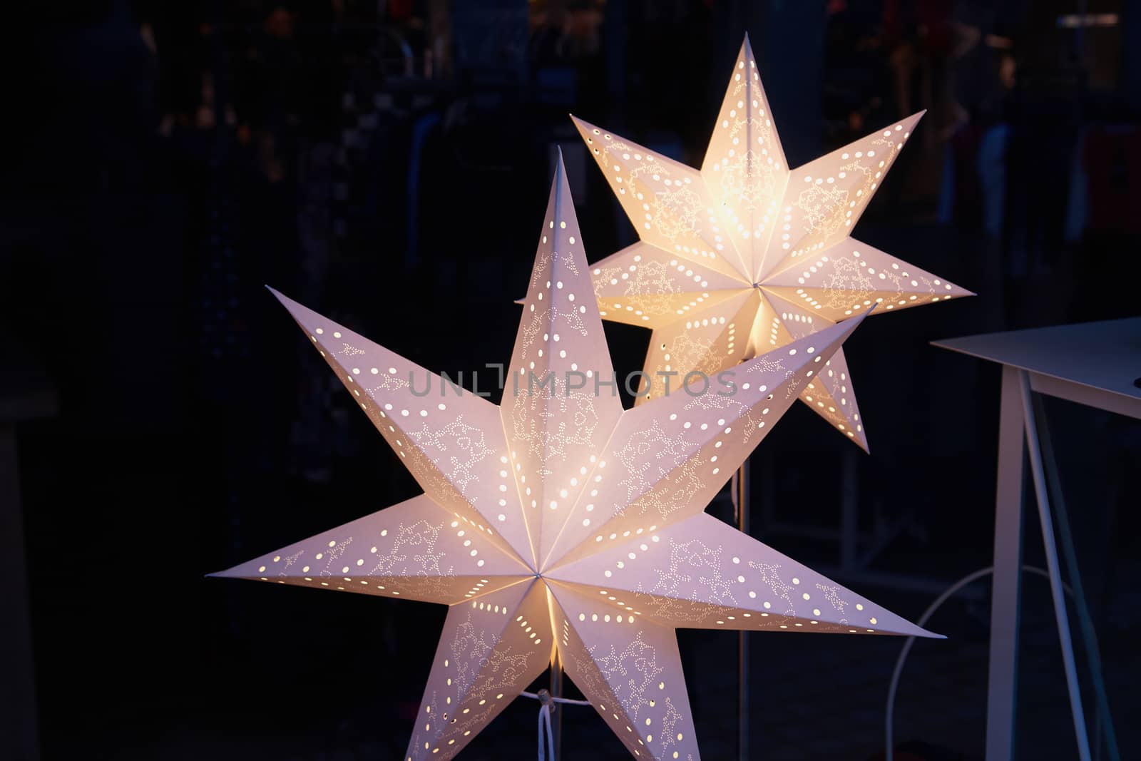 White glittering beautiful handmade star shaped Christmas decoration with dark background                              