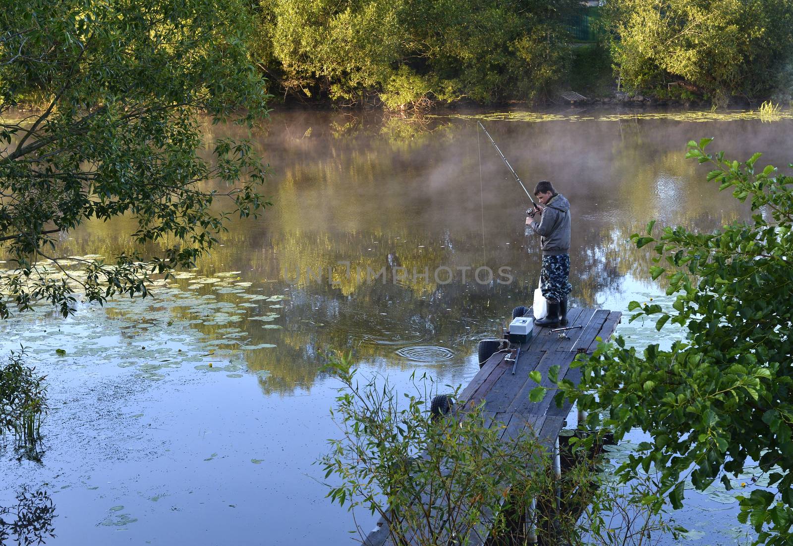 Fishing on a river from the bridge at early morning