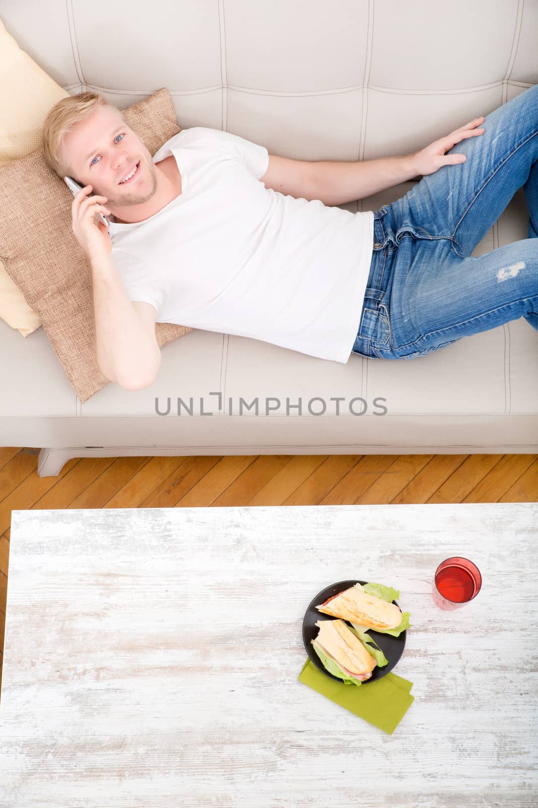 Young man with a Sandwich on the Sofa  by Spectral