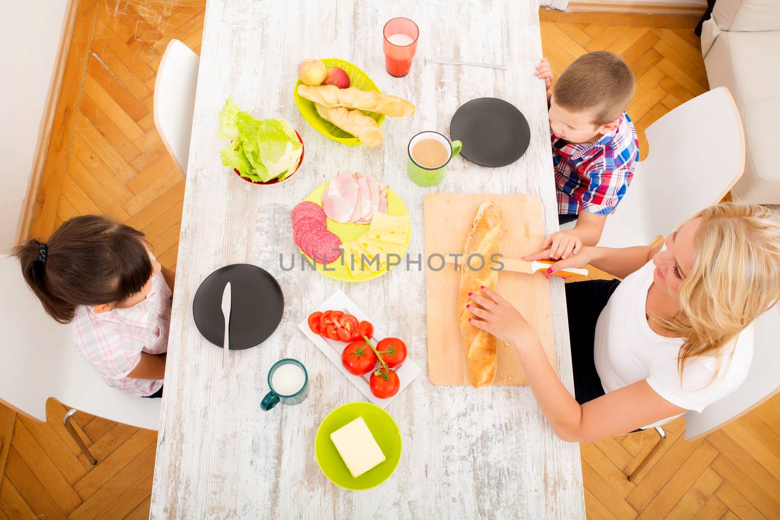 A mother and her children having breakfast at home.

