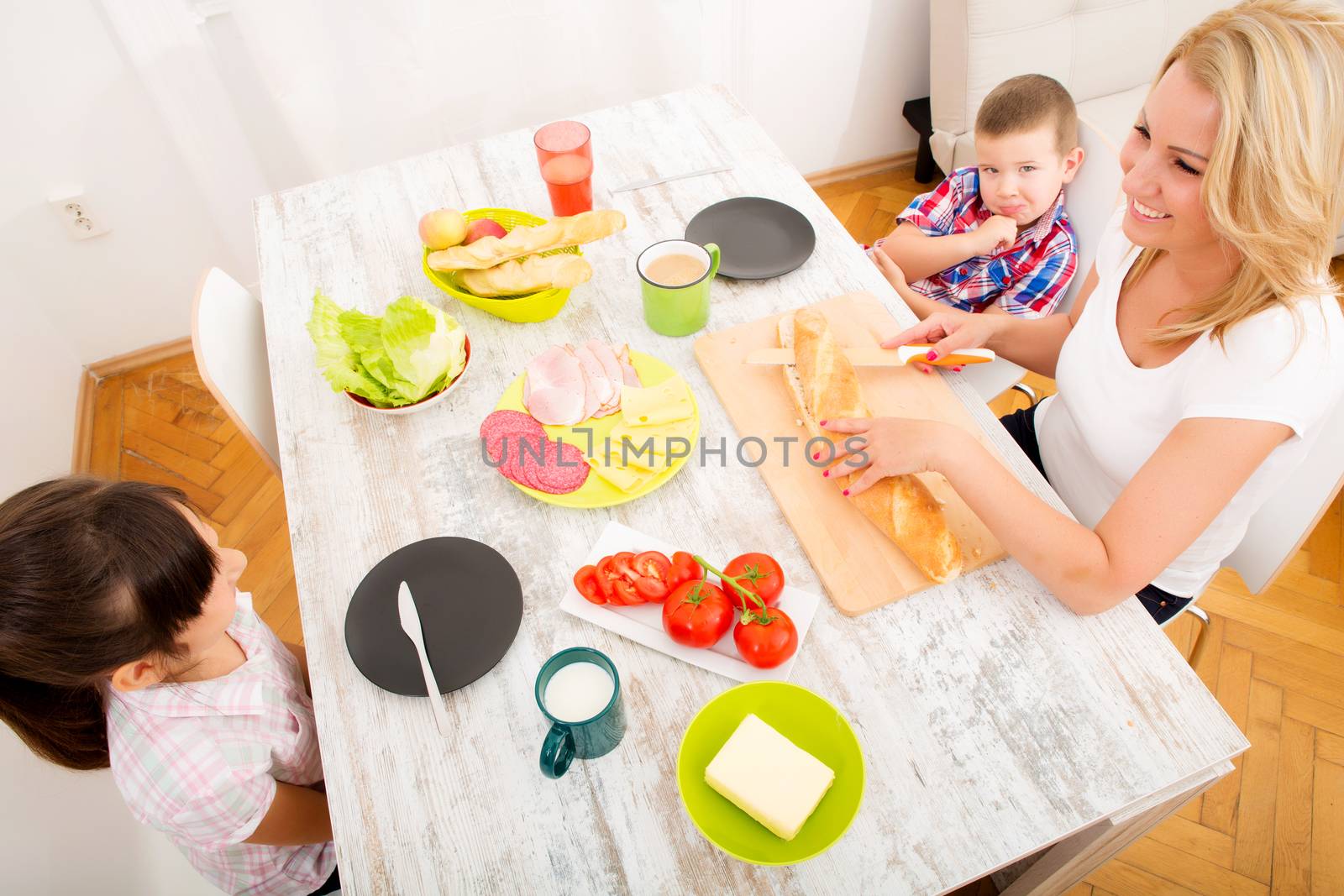 A mother and her children having breakfast at home.
