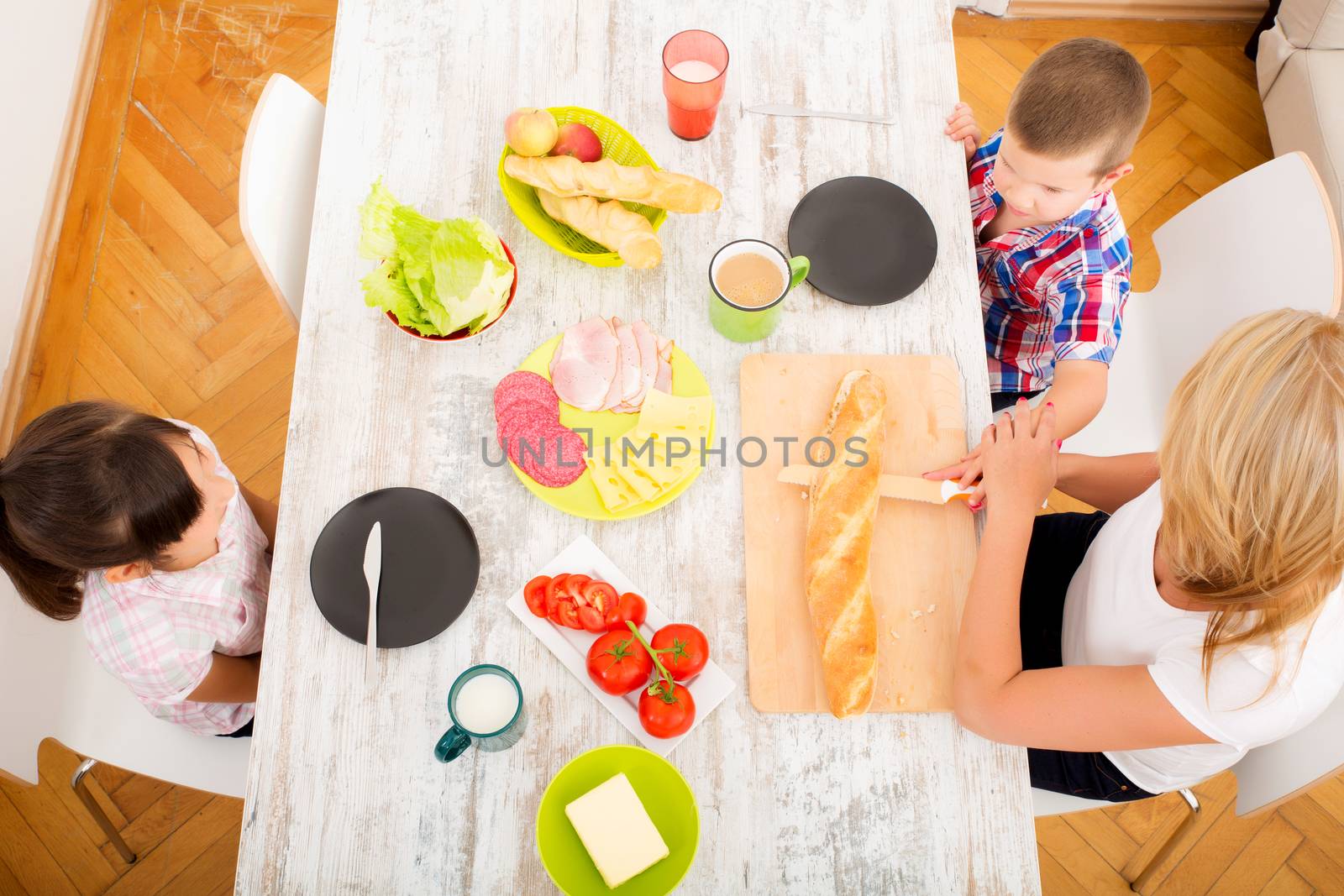 Happy family having breakfast at home by Spectral