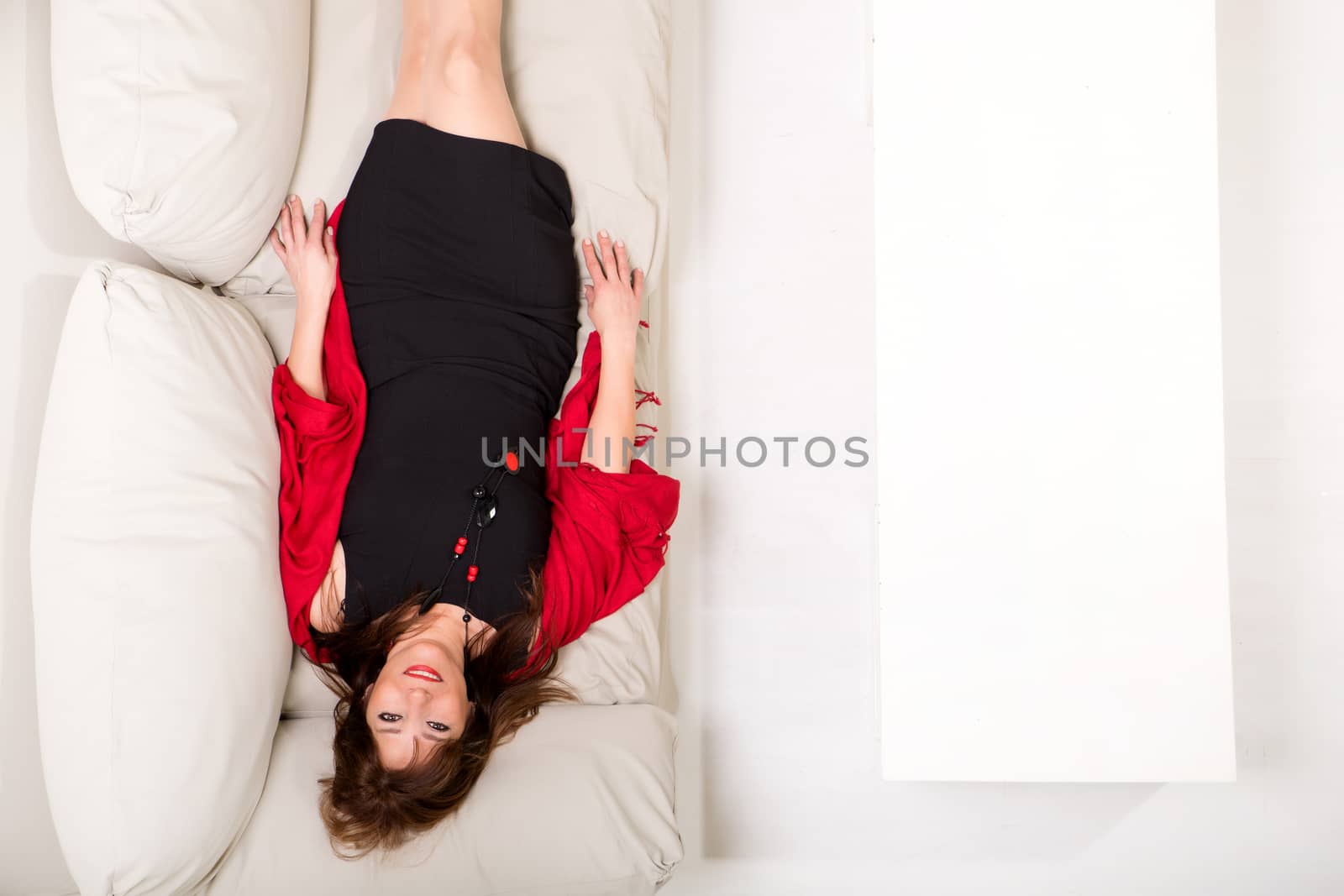 A beautiful mature woman lying on the sofa at home.
