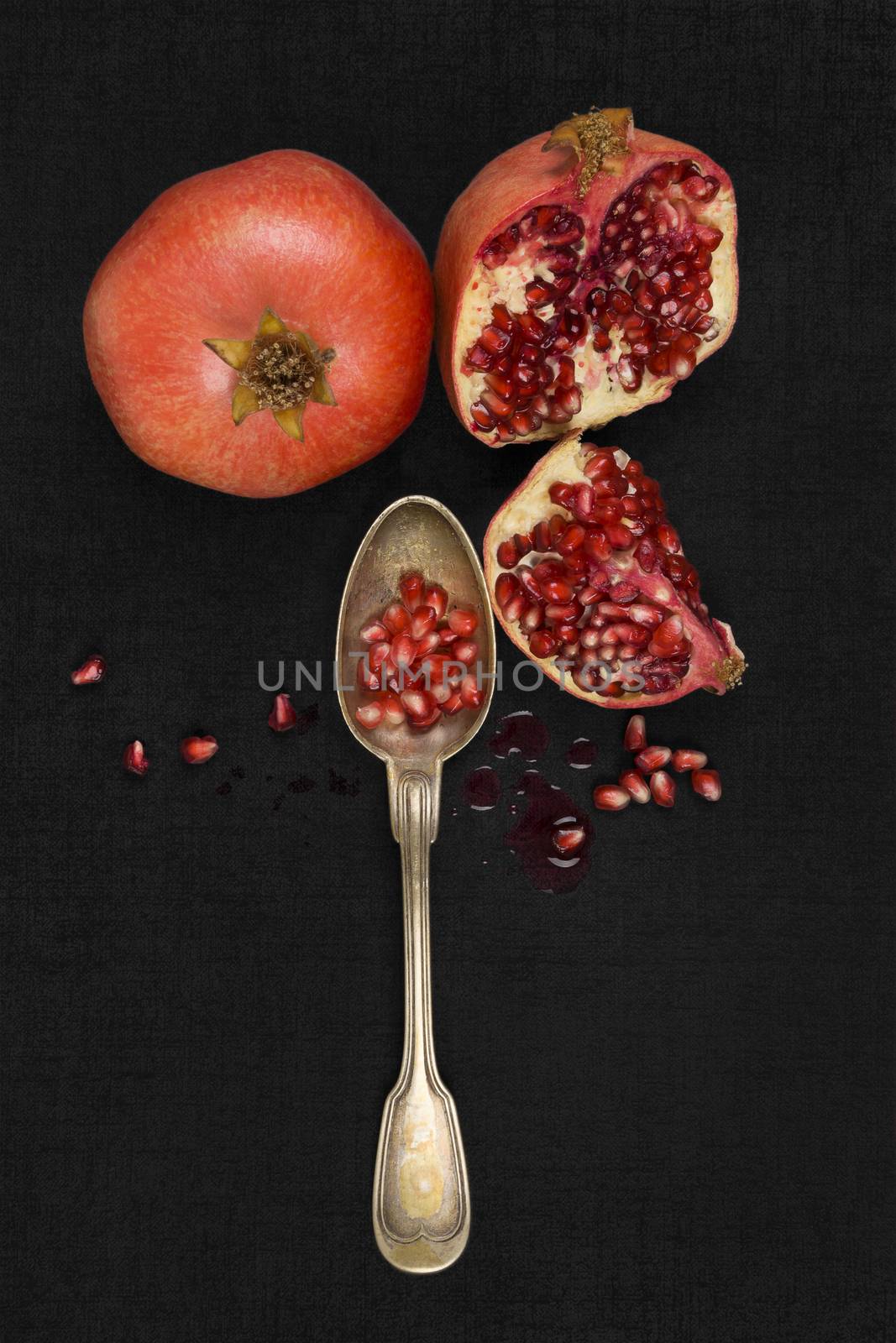 Fresh pomegranate background. Pomegranate core on black background, top view. Healthy fruit eating.