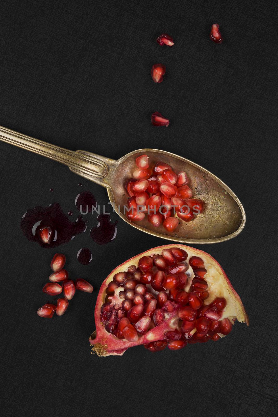 Healthy pomegranate background. Pomegranate core on black background, top view. Healthy fruit eating.