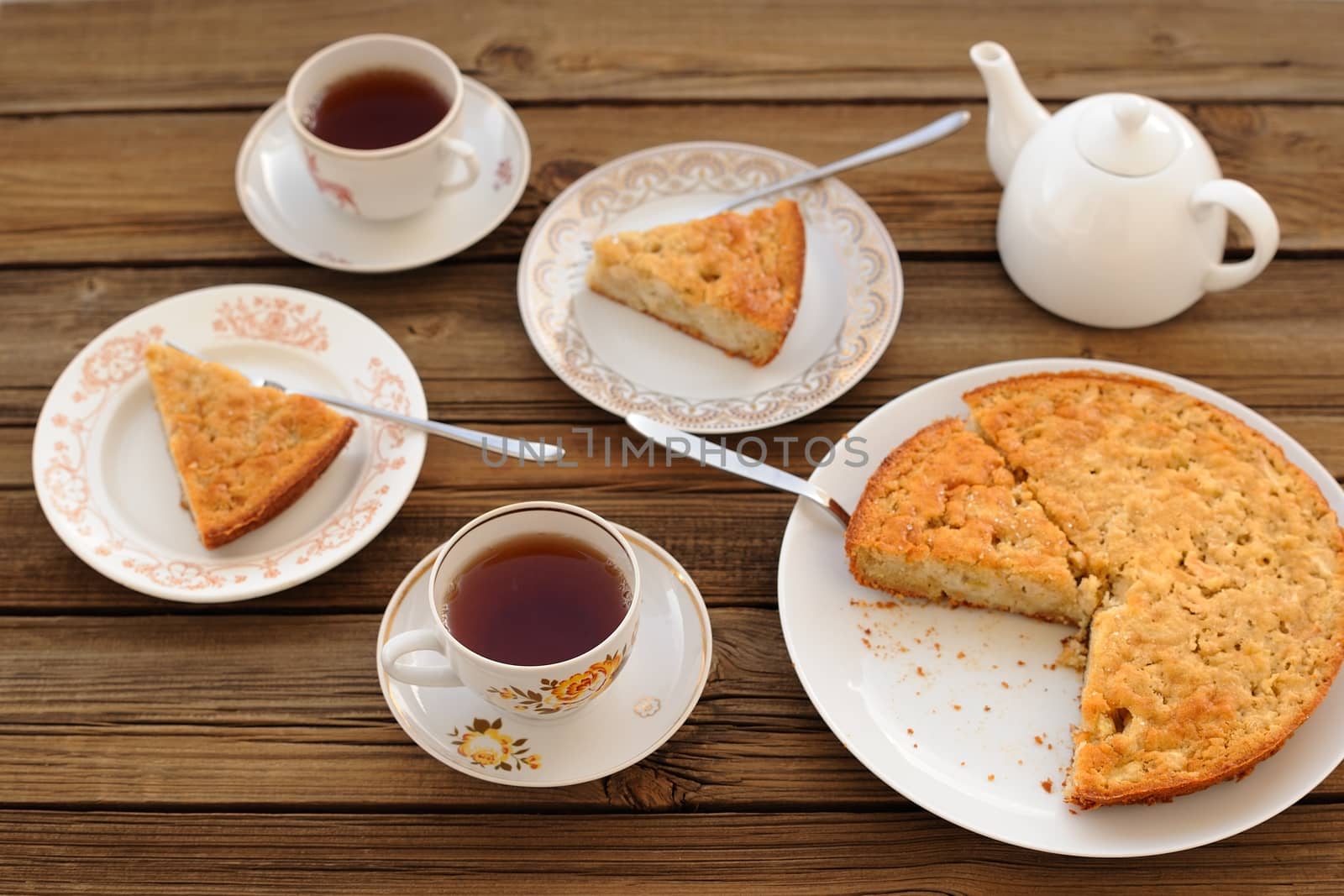 Old-fashioned apple pie with black tea on wood background