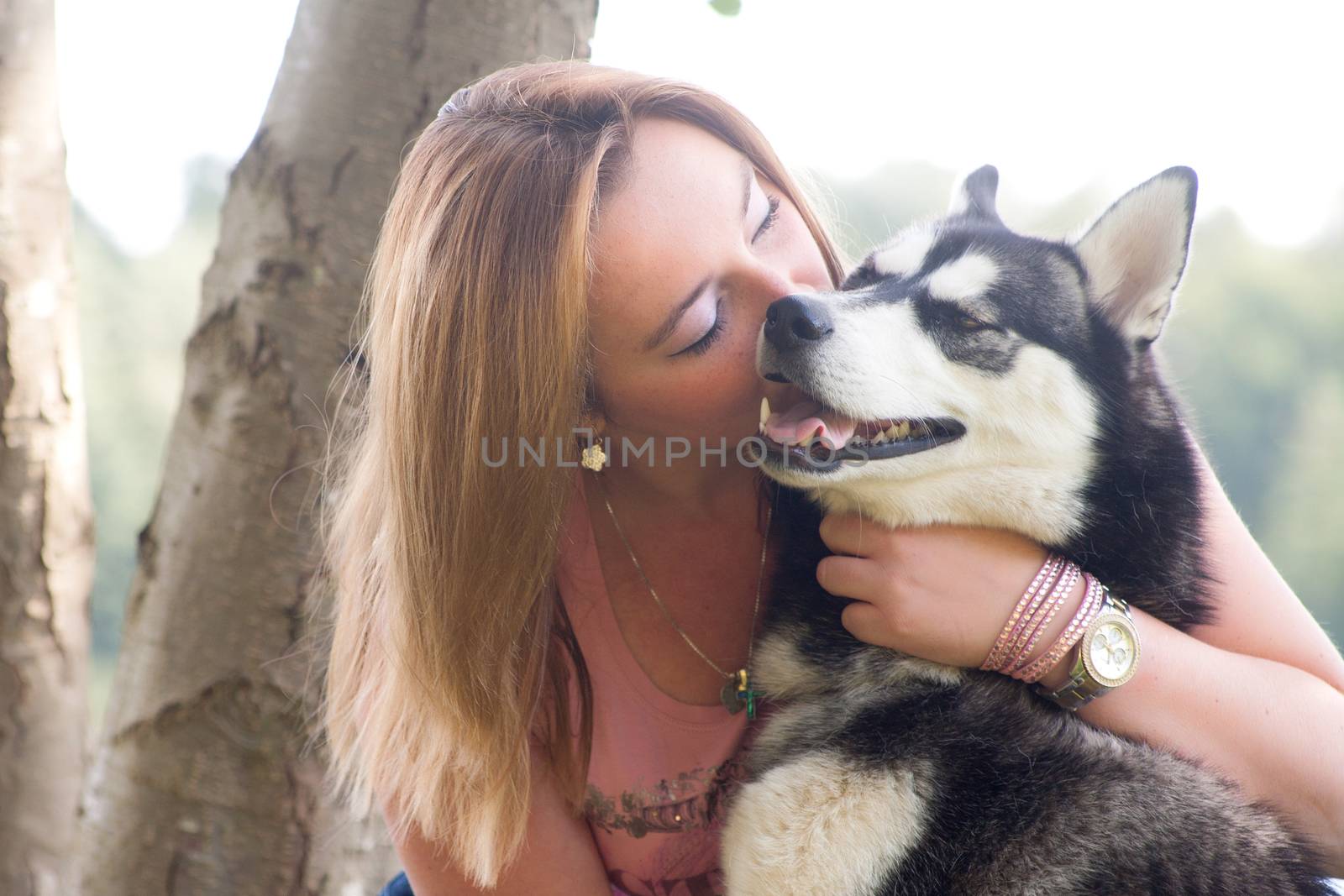 Young woman and her husky in the forest